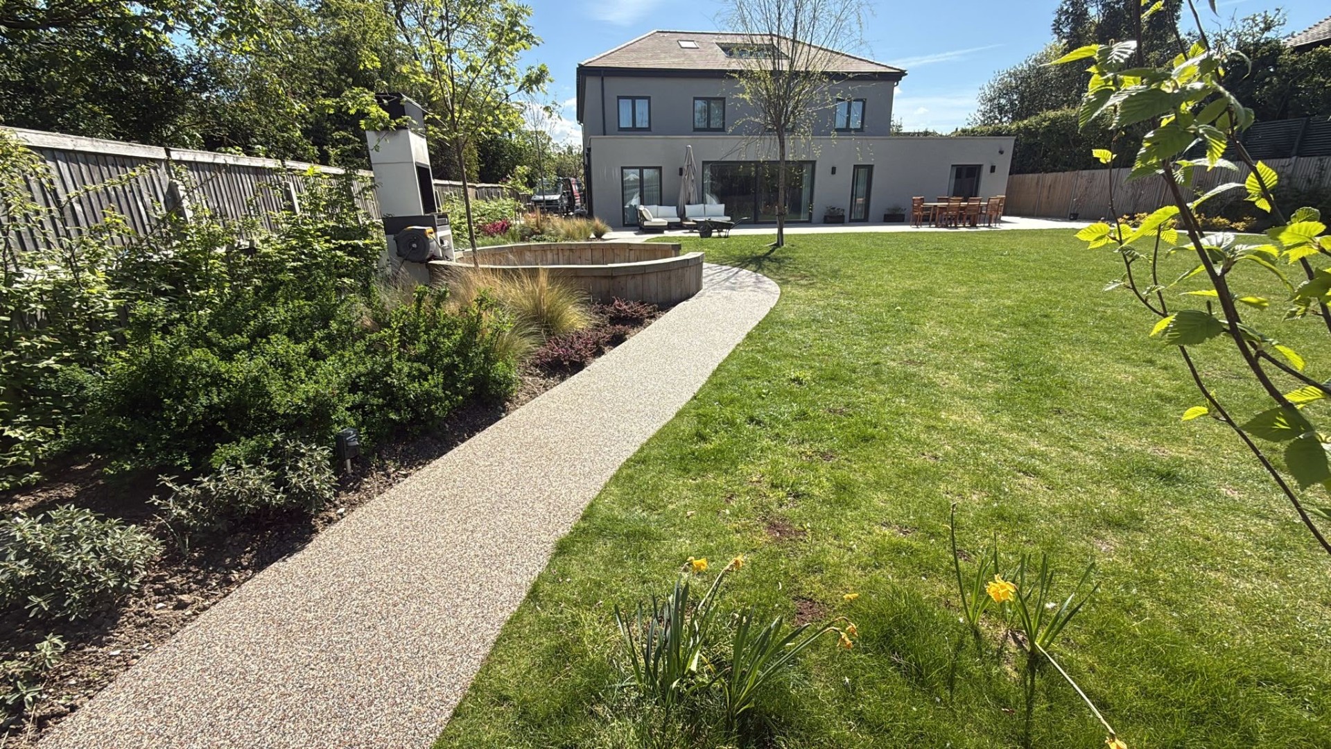 Sweeping resin bound garden path curving around a lawn