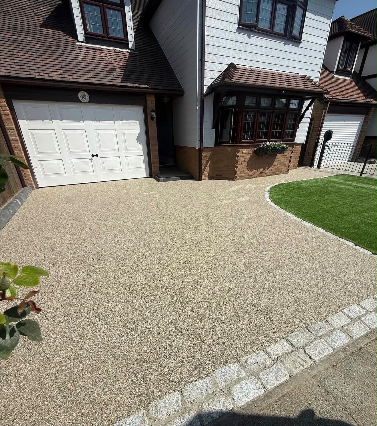 Gold resin bound driveway with cobble border at a detached family home