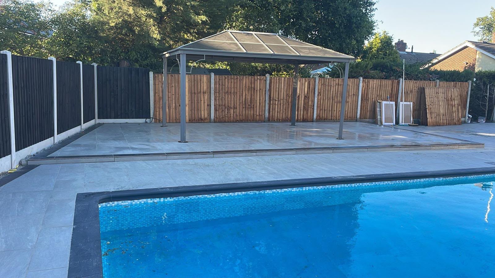 Large porcelain paved pool surround with gazebo