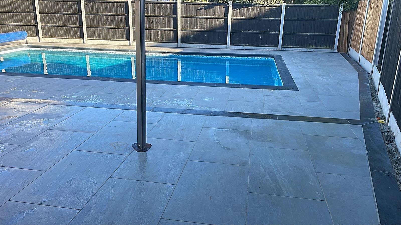 Craftsman precisely laying premium block paving in warm sunlight