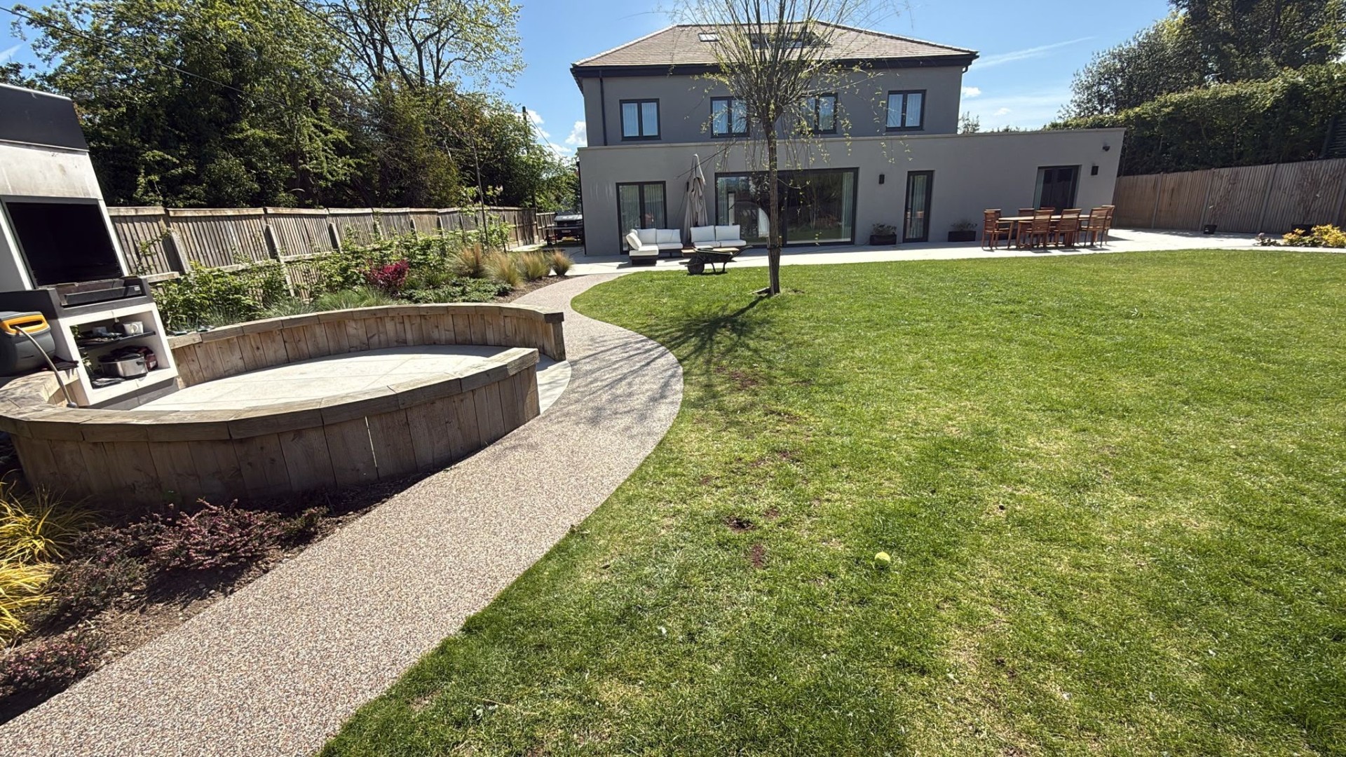 Curved resin bound garden path leading to a contemporary home